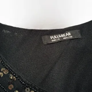 Vestido negro con lentejuelas negras y doradas.