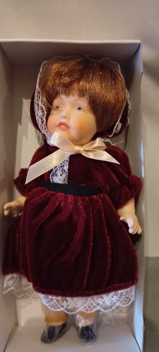 Muñeca de porcelana con vestido de terciopelo