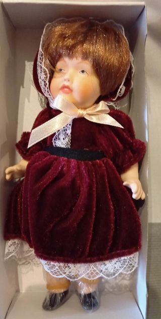 Muñeca de porcelana con vestido de terciopelo