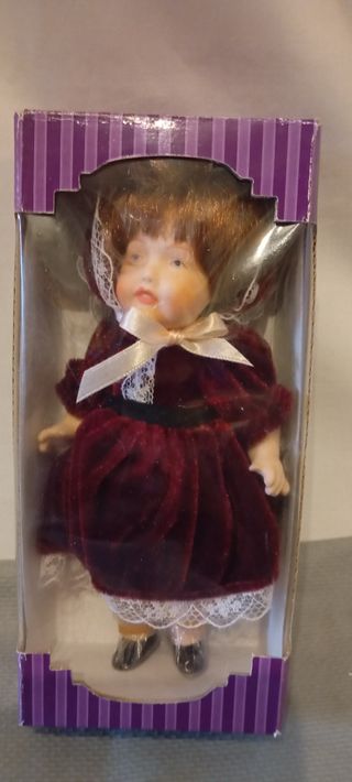 Muñeca de porcelana con vestido de terciopelo