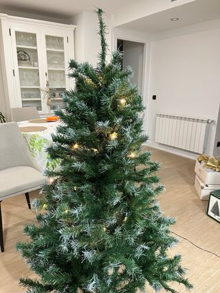 Árbol de Navidad con adornos blancos y dorados.