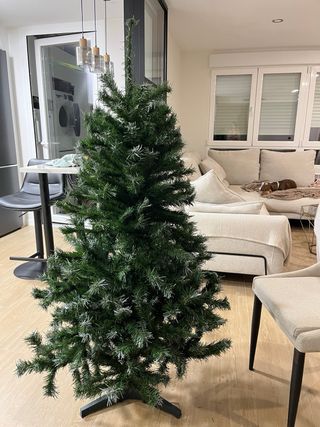 Árbol de Navidad con adornos blancos y dorados.