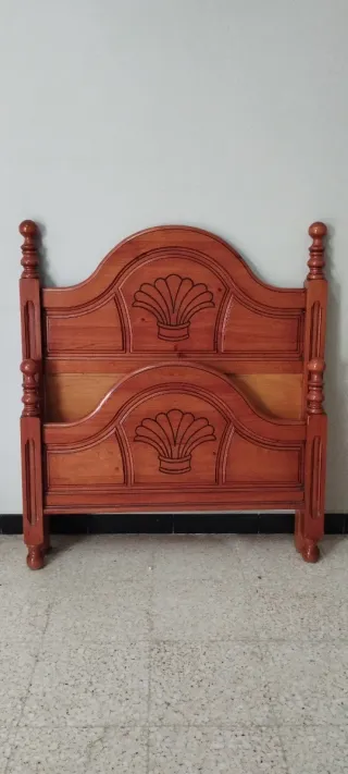 Cama de madera con cabecero tallado