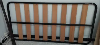 Cama de madera con cabecero tallado