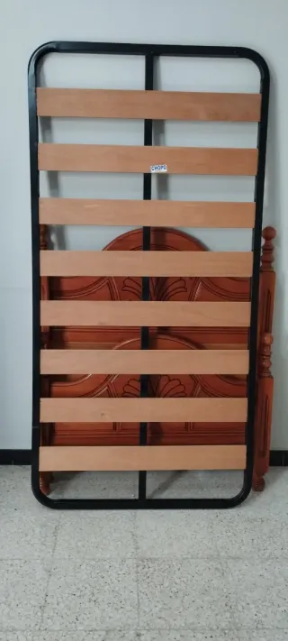 Cama de madera con cabecero tallado