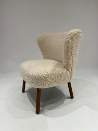 Butaca cruda de tela con patas de madera