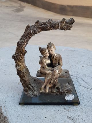 Coppia seduta su panchina statuetta