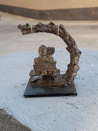 Coppia seduta su panchina statuetta