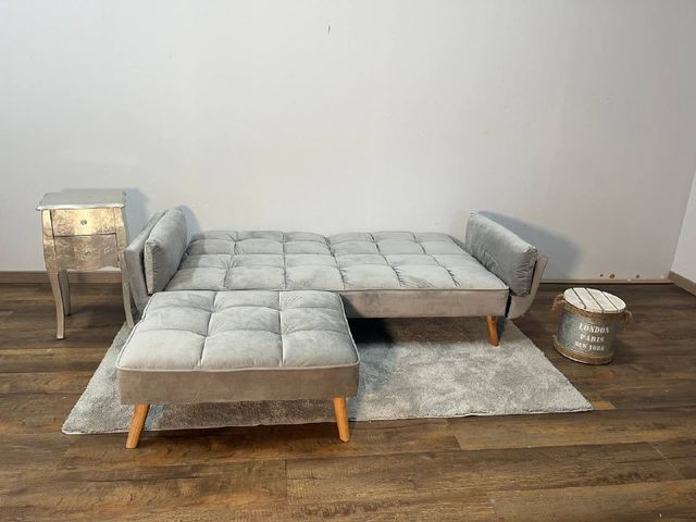 Sofá gris moderno con chaise longue a juego y puff