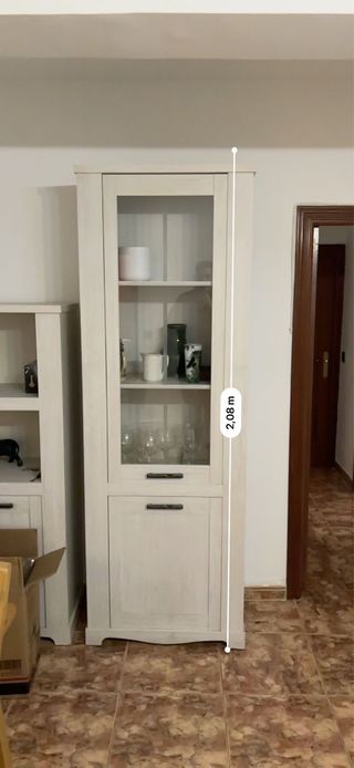 Vitrina alta blanca con puertas de cristal.