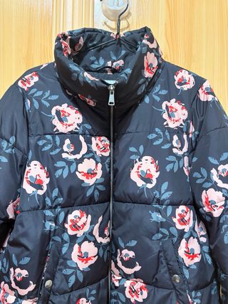 Plumífero negro con flores rosas