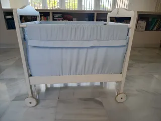 Minicuna blanca con textiles celestes