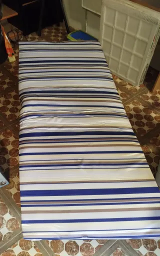 Cama plegable azul con rayas