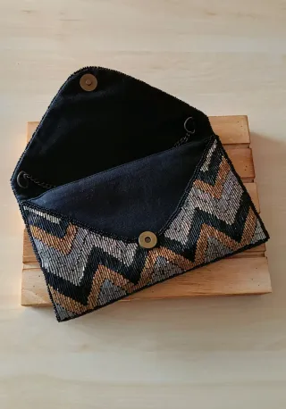 Cartera de mano con cadena y diseño zigzag
