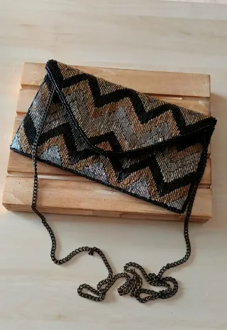 Cartera de mano con cadena y diseño zigzag