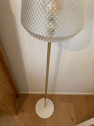 Lámpara de pie dorada y transparente
