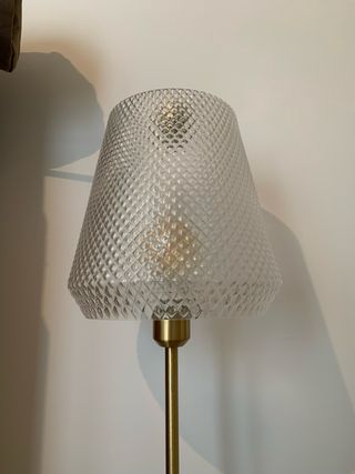 Lámpara de pie dorada y transparente