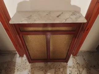 Cubre radiador de mármol, madera y ratán