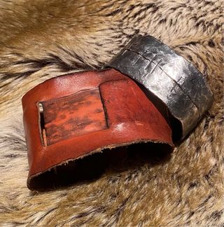 Brazalete de cuero con centro de metal.