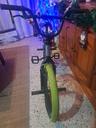 Bicicleta BMX argentata con ruote gialle