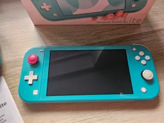 Nintendo Switch Lite Verde + FIFA 21 en su caja.