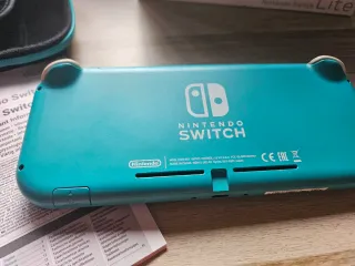 Nintendo Switch Lite Verde + FIFA 21 en su caja.