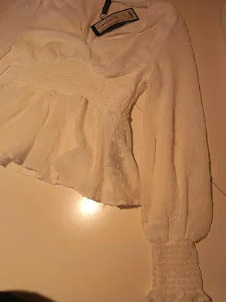 Blusa blanca con volantes y manga larga