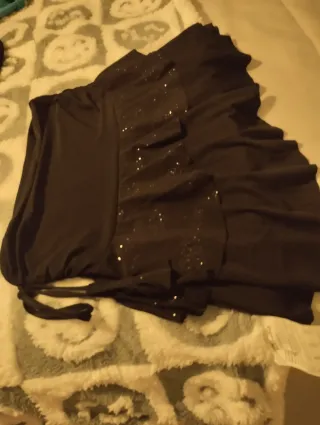 Minifalda negra con volantes y brillantes.