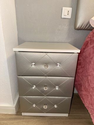 Cabecero de cama plateado y dos mesitas a juego .