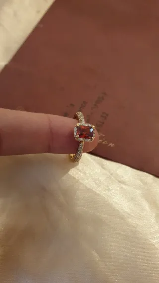 Anillo dorado con piedra roja y circonitas