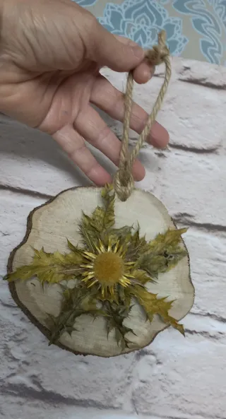 Eguzkilore artesanal sobre rodaja de árbol