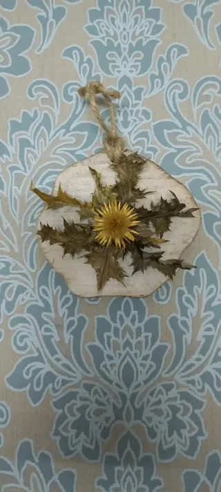 Eguzkilore artesanal sobre rodaja de madera