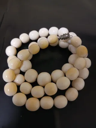 Collar de cuentas beige y blancas.