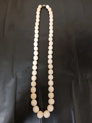 Collar de cuentas beige y blancas.