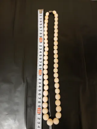 Collar de cuentas beige y blancas.