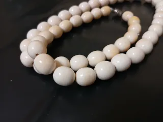 Collar de cuentas beige y blancas.