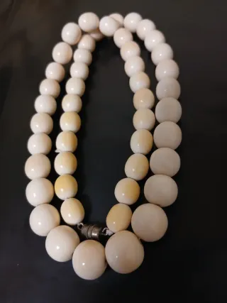 Collar de cuentas beige y blancas.