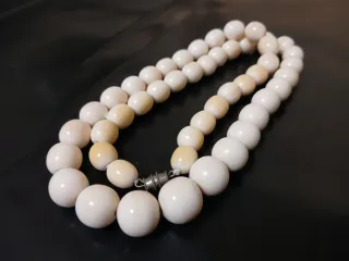 Collar de cuentas beige y blancas.