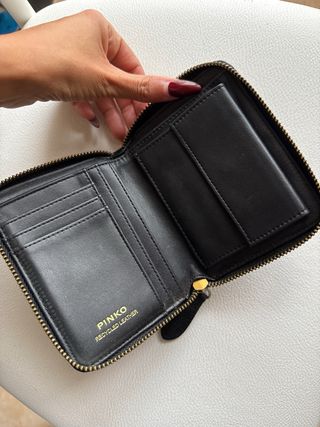 Borsa Pinko nera con dettagli oro e portafoglio