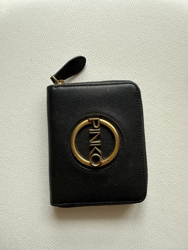 Borsa Pinko nera con dettagli oro e portafoglio