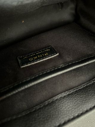 Borsa Pinko nera con dettagli oro e portafoglio