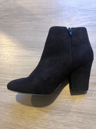 Botines negros tacón con cremallera dorada.