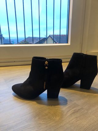 Botines negros tacón con cremallera dorada.