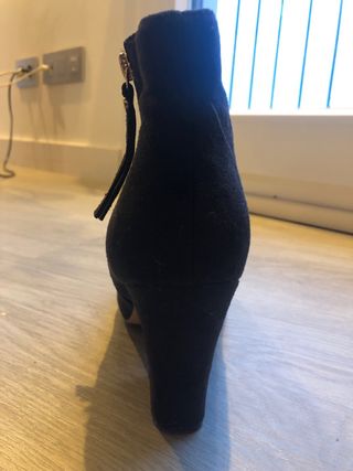 Botines negros tacón con cremallera dorada.