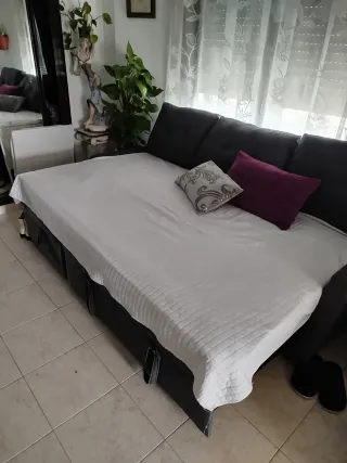 Sofá cama gris con chaiselongue y almacenaje