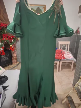 Traje de flamenca verde y peineta a juego.