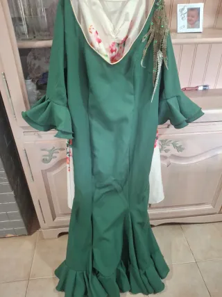 Traje de flamenca verde y peineta a juego.