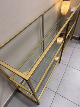 Estantería dorada de metal y cristal