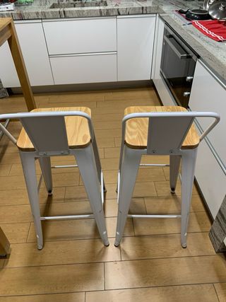 Juego de 2 sillas altas de metal y madera.