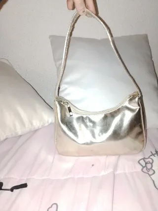 Bolso dorado con joyas